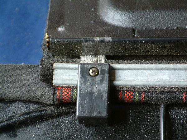 A cet endroit la plage arrière est maintenue par ce renfort et la vis est prise dans du tissu élastique