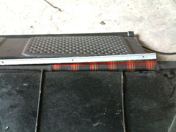 la moquette de la plage arrière est fixée entre le dossier et cette barre